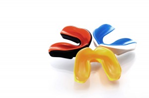 Drei Zahnschutz Schienen für den Sport in den Farben Gelb, Blau-Weiß und Rot-Schwarz